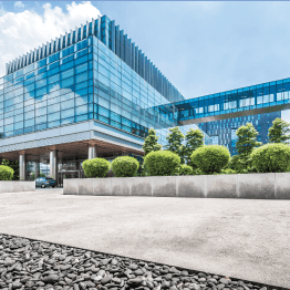 A large glass building with a car parked in front of it