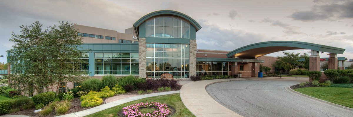 A large building with a lot of windows and a driveway leading to it.