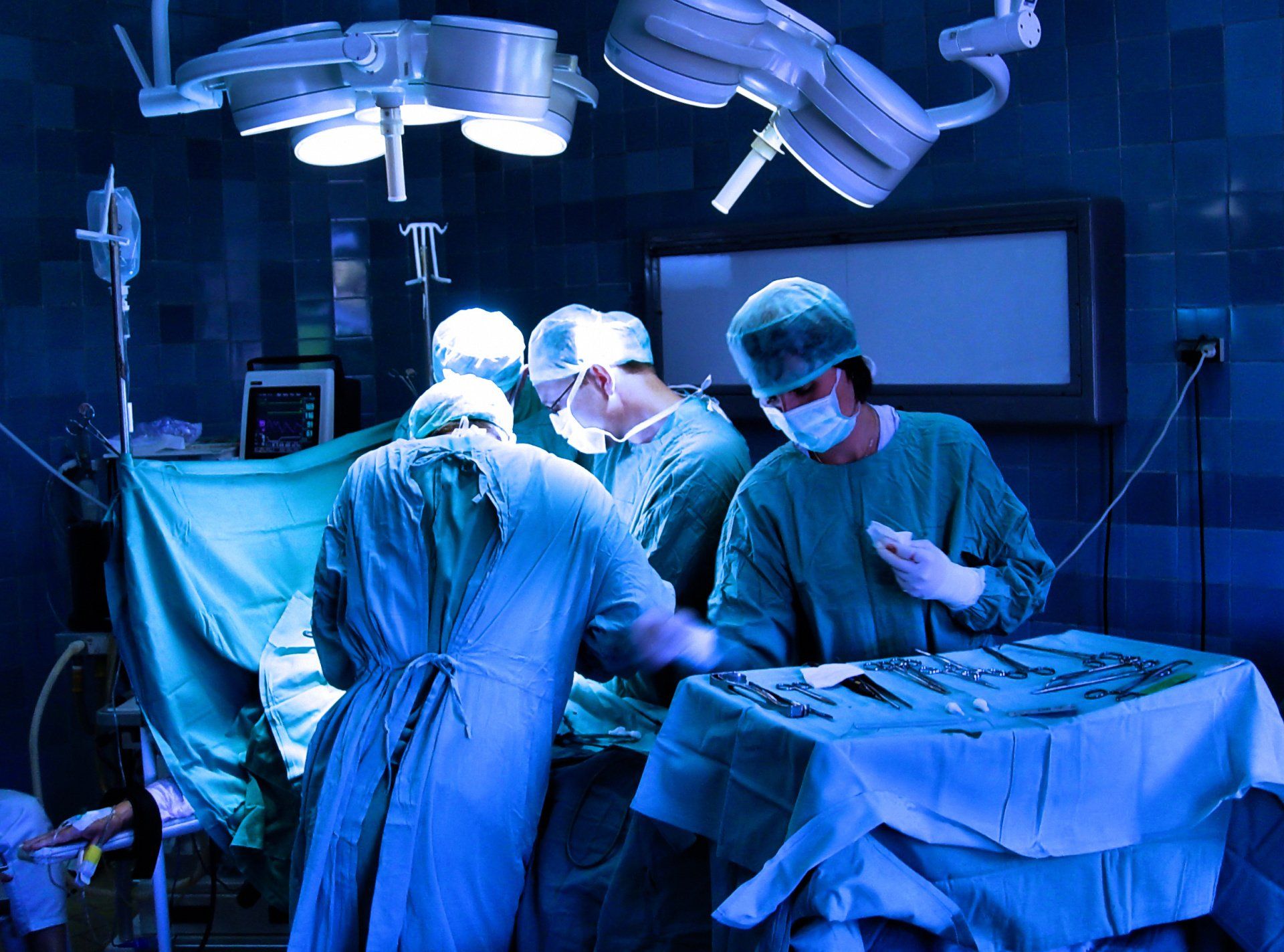 A group of surgeons are performing surgery in an operating room