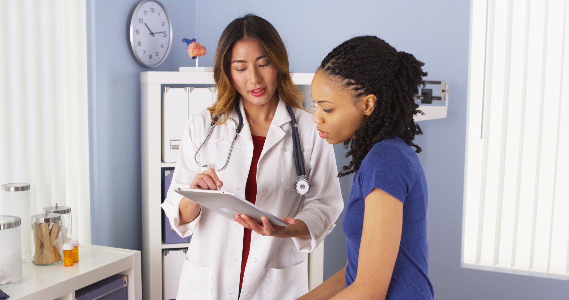 A doctor is talking to a patient in a doctor 's office.