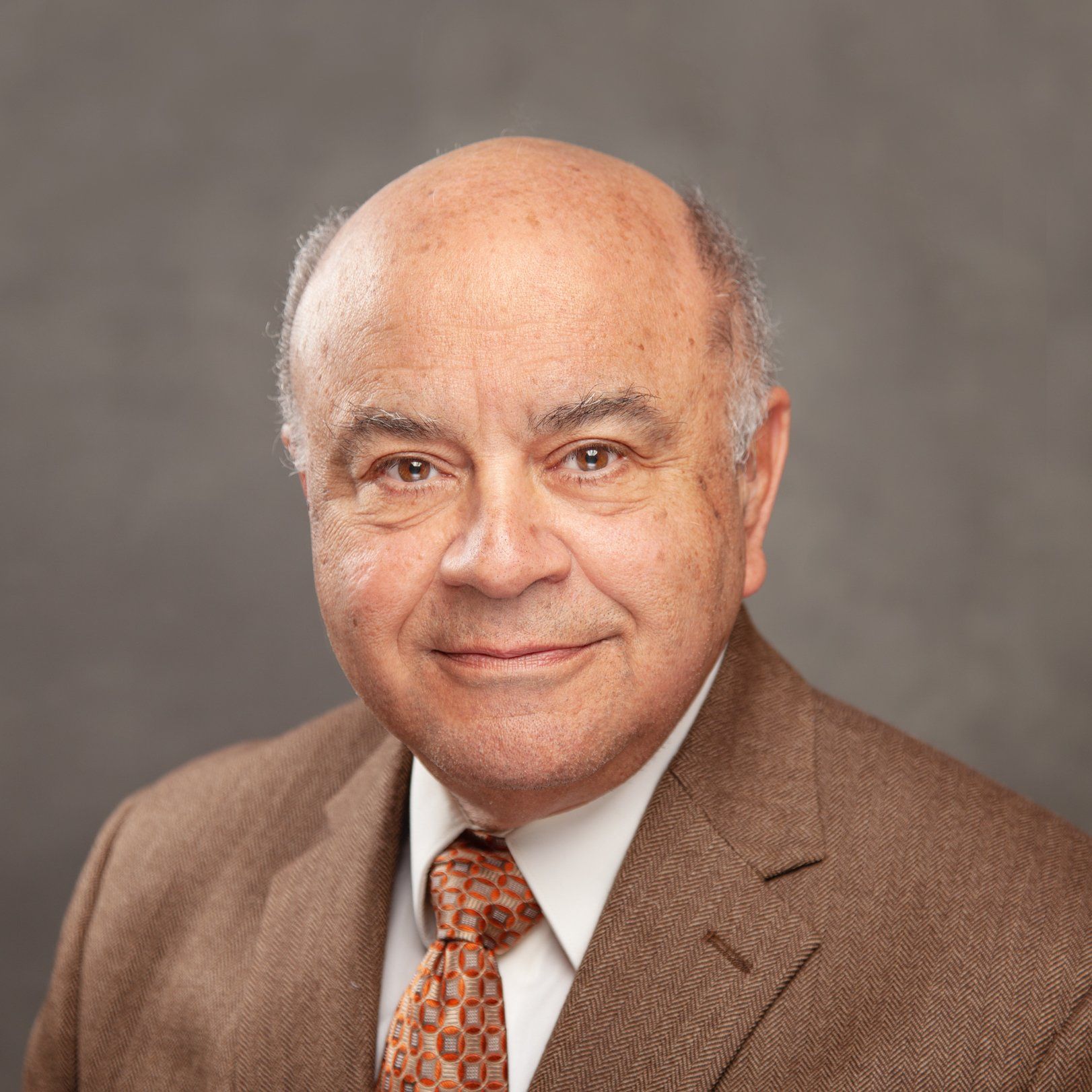 A man in a suit and tie is smiling for the camera