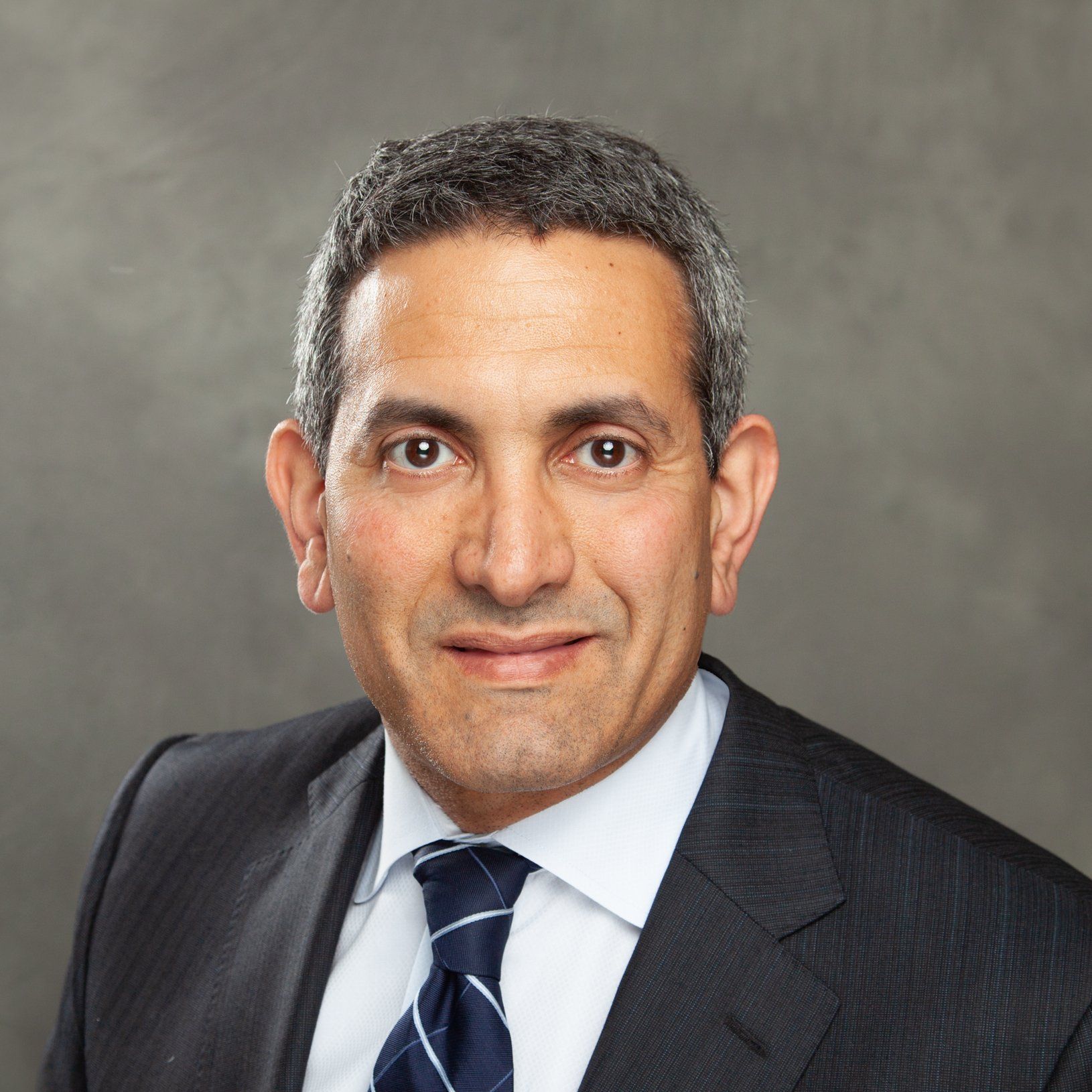 A man in a suit and tie is smiling for the camera.