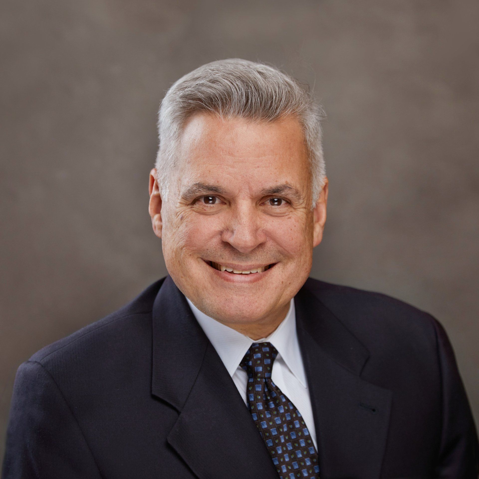 A man in a suit and tie is smiling for the camera.