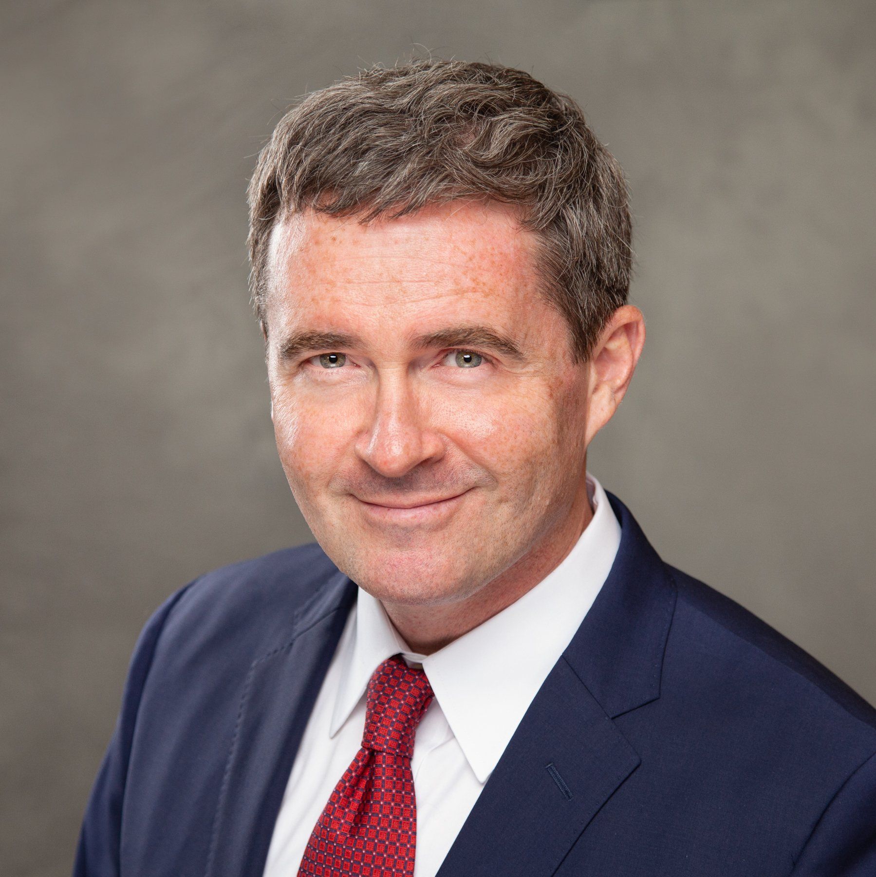 A man in a suit and tie is smiling for the camera.