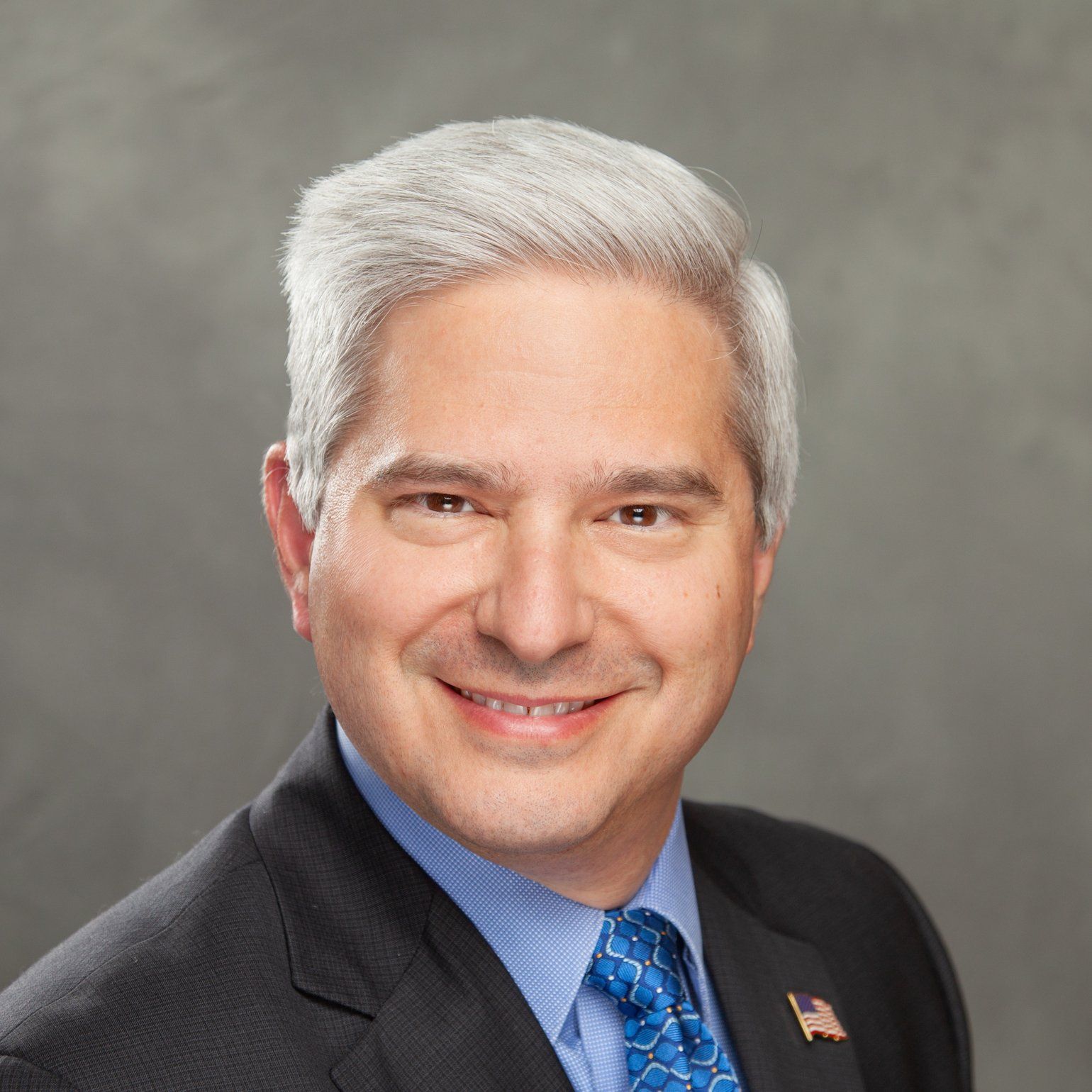 A man in a suit and tie is smiling for the camera.