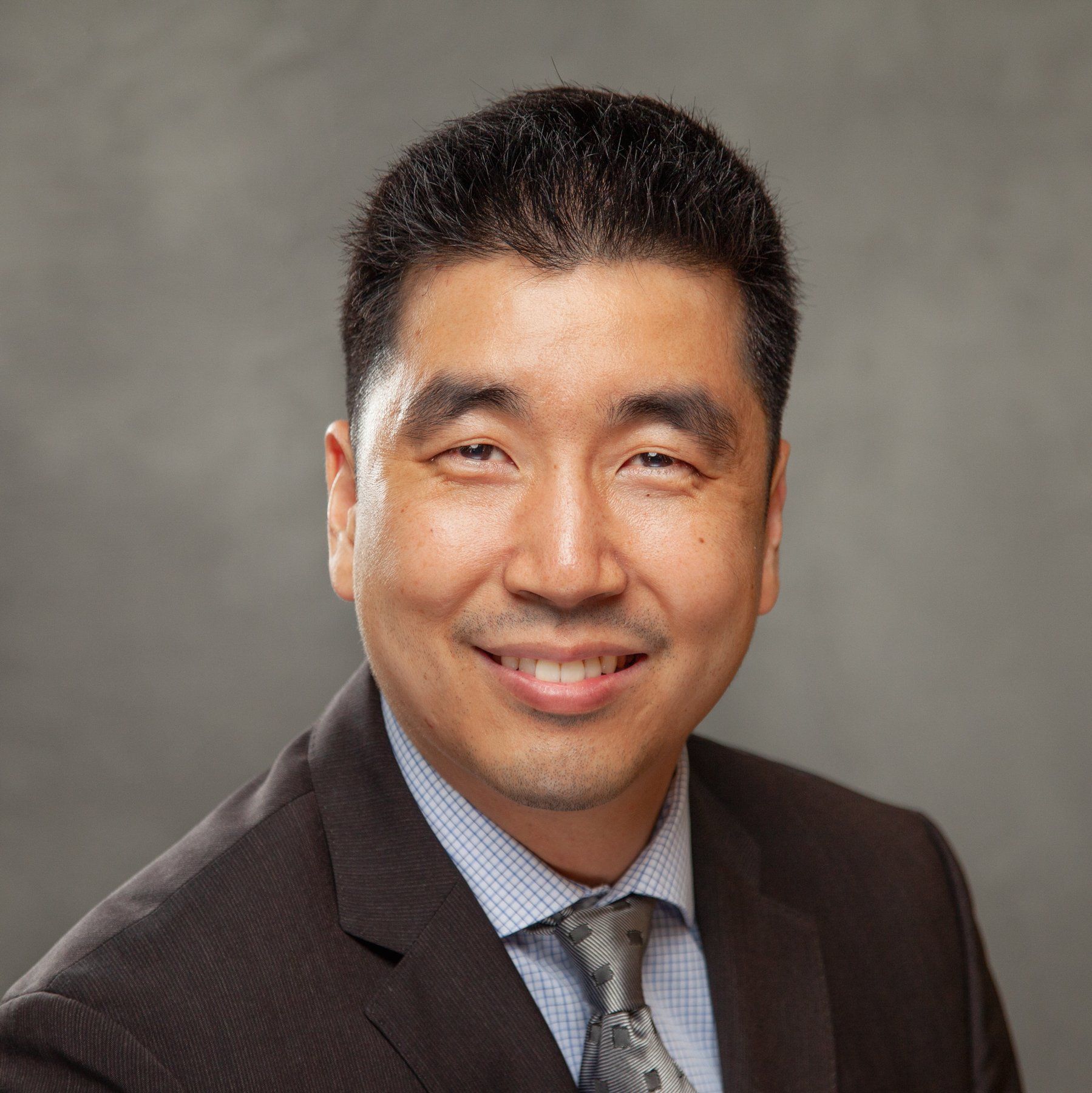 A man in a suit and tie is smiling for the camera.