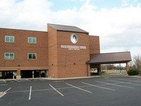 A large brick building with a parking lot in front of it.