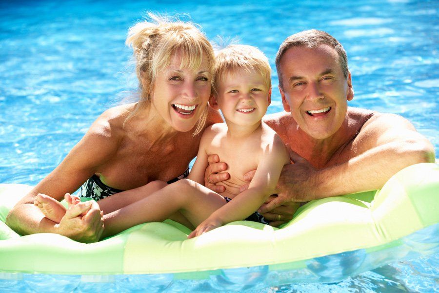 Grandparents And Grandson Having Fun In Swimming Pool — Liverpool, NY — CoolWaters Pool & Spa Grandparents And Grandson Having Fun In Swimming Pool — Liverpool, NY — CoolWaters Pool & Spa
