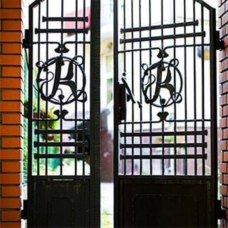 Black wrought iron and brick entrance gates — window guards in Torrance, CA Black wrought iron and brick entrance gates — window guards in Torrance, CA
