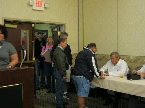 A group of people standing around a table with an exit sign above them