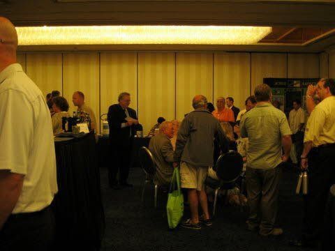 A group of people are standing in a room talking to each other.