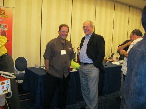 Two men are standing next to each other in a room.