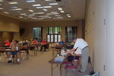 A group of people are sitting at tables in a large room.