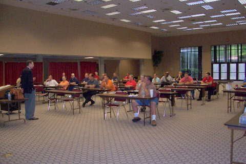 A group of people are sitting at tables in a large room.