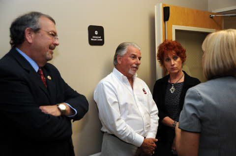 A group of people are standing in a room talking to each other.
