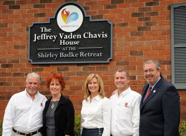 A group of people standing in front of a sign that says the jeffrey vaden chavis house at the shirley badke retreat