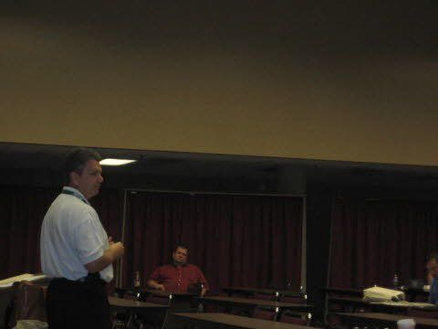A man is giving a presentation in front of a group of people in a conference room.