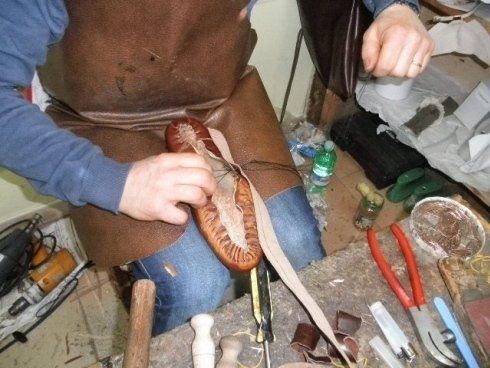esperto artigiano mentre produce un paio di scarpe