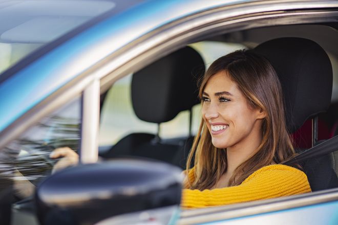 Girl smiling behind the wheel — Clearwater, FL — Nichols & Dimes Rent A Car Inc Girl smiling behind the wheel — Clearwater, FL — Nichols & Dimes Rent A Car Inc