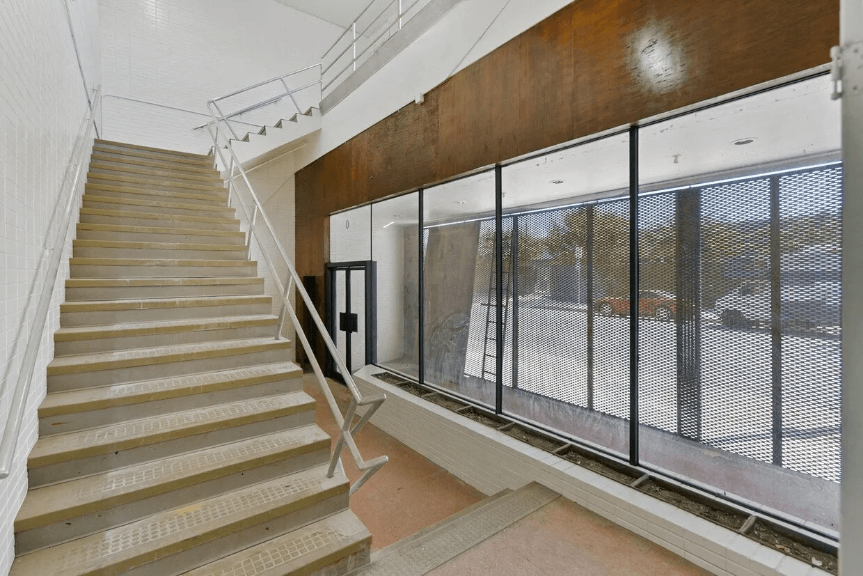 A set of stairs leading up to a large window in a building.