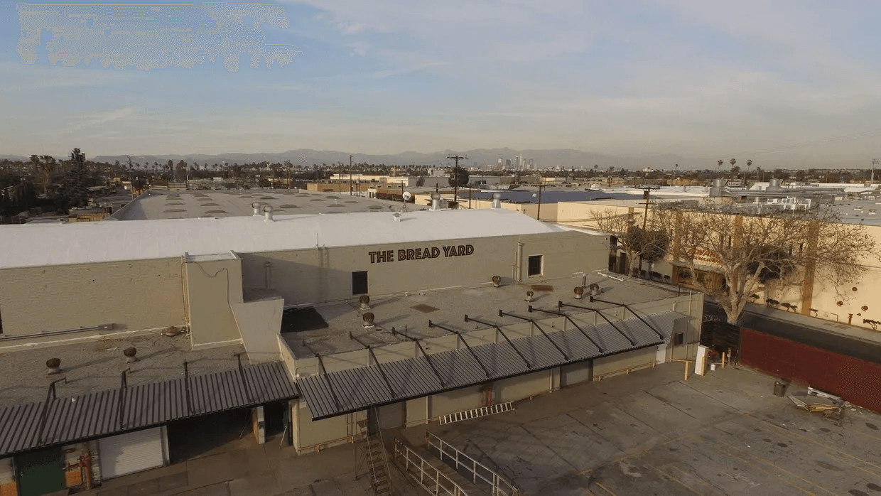 An aerial view of a large building with a white roof.