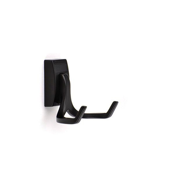 A black hook is hanging on a white wall.