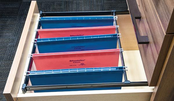 A drawer filled with blue and red file folders.