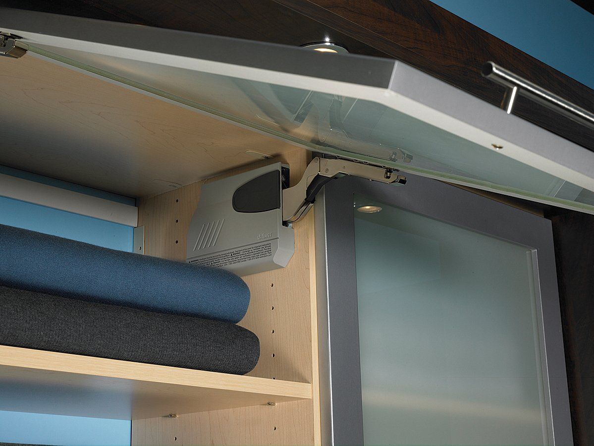 A cabinet with the door open and a stack of towels on the shelf.