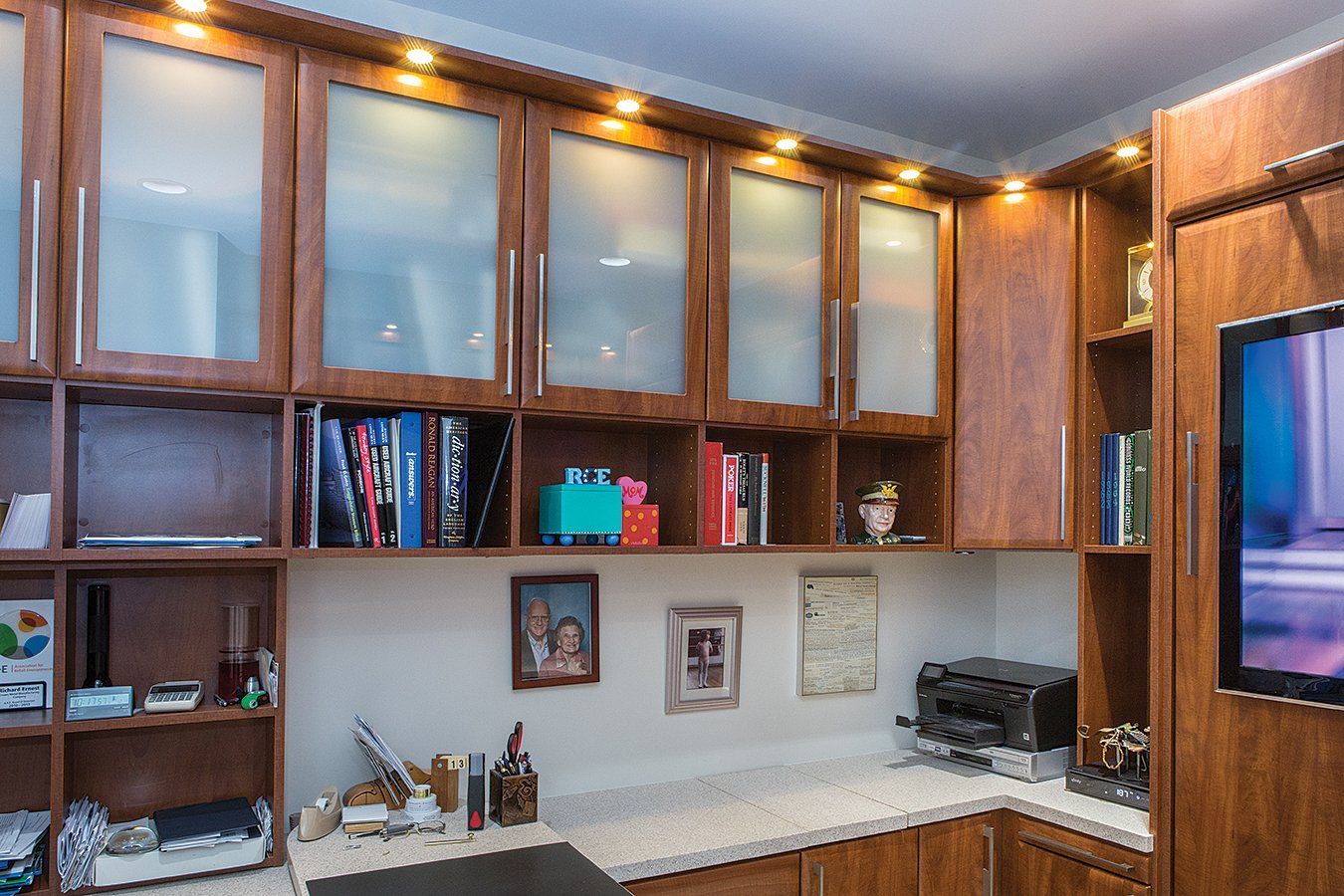 A kitchen with wooden cabinets and a flat screen tv