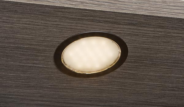 A close up of a light on a wooden surface.