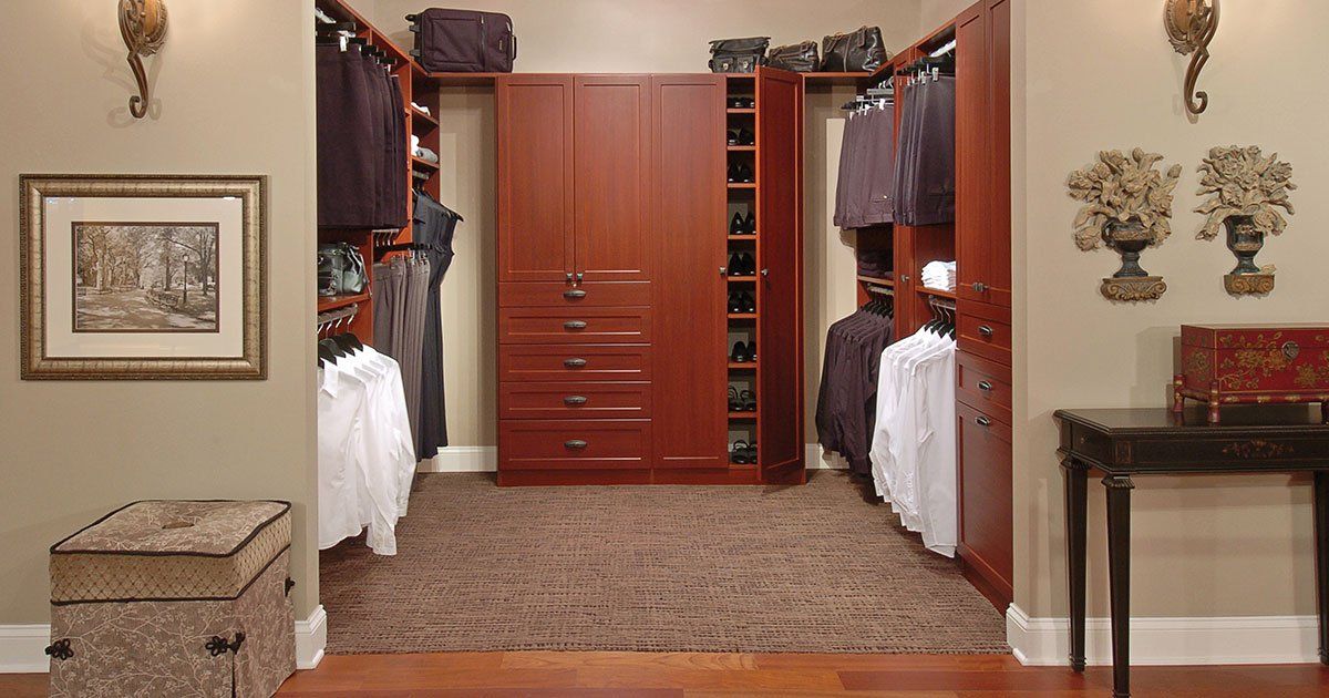 A walk in closet with wooden cabinets and drawers