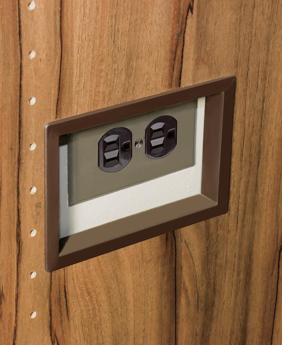 A picture of an electrical outlet on a wooden wall.
