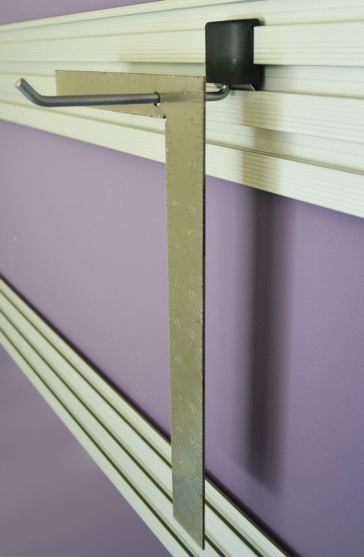 A metal hook is attached to a purple wall