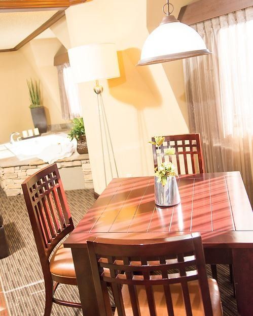 Dining area: wooden table, chairs, floor lamp, overhead light.