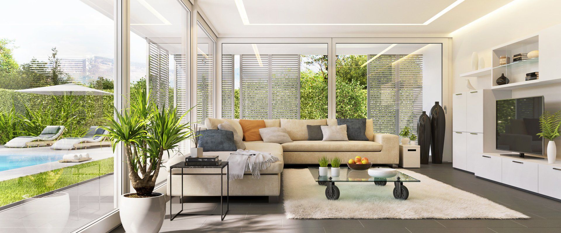 A living room with a couch , television , and sliding glass doors leading to a swimming pool.