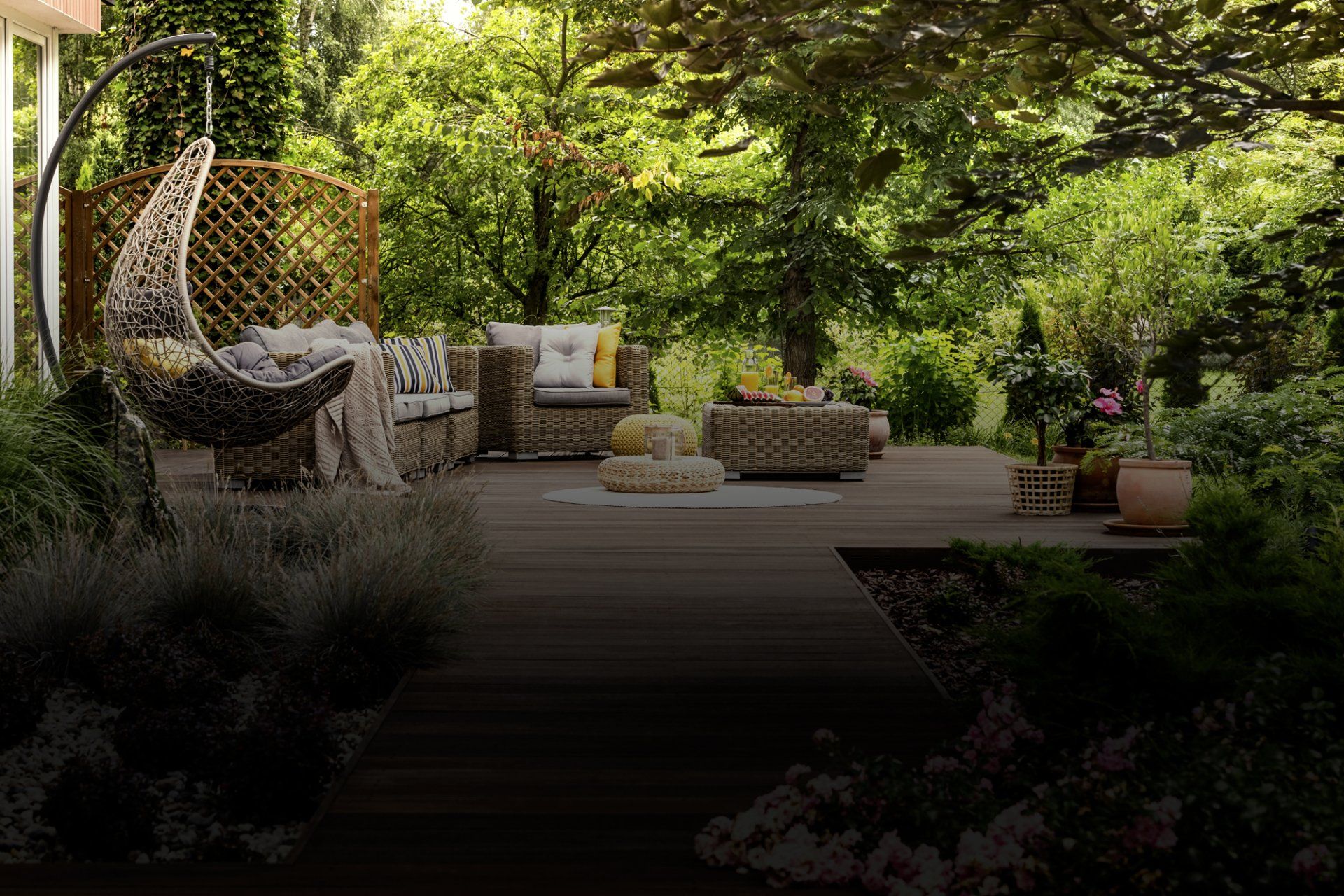 A patio with wicker furniture and a hanging chair.