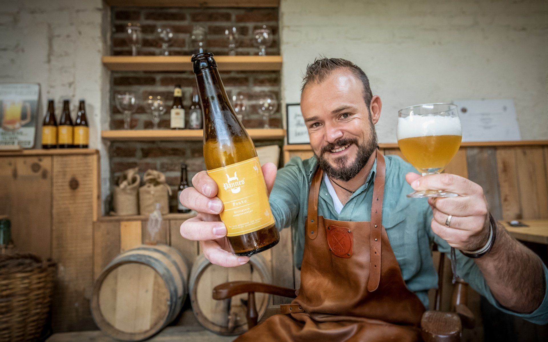 Een lachende brouwer met zijn heerlijk smakende biertje. Gewoon trots
