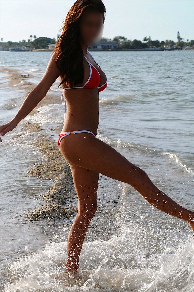A woman in a red bikini is standing in the water