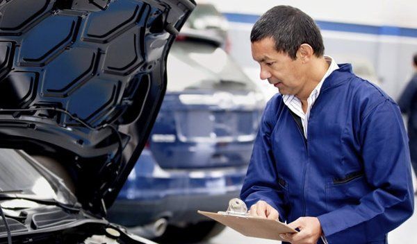 man-in-blue-checking-car