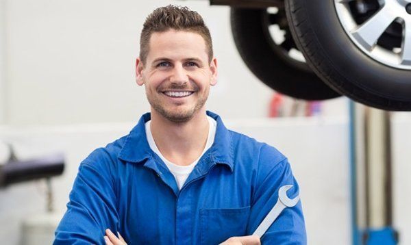 man-in-blue-smiling-holding-tool