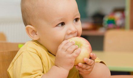 little child eating an apple