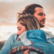 A man is hugging a woman in a denim jacket.