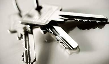 Close-up of a silver keyring with several metal keys on a blurred background