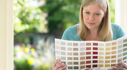 Woman looking at color chart — Garage Door Services in Green River, WY Woman looking at color chart — Garage Door Services in Green River, WY