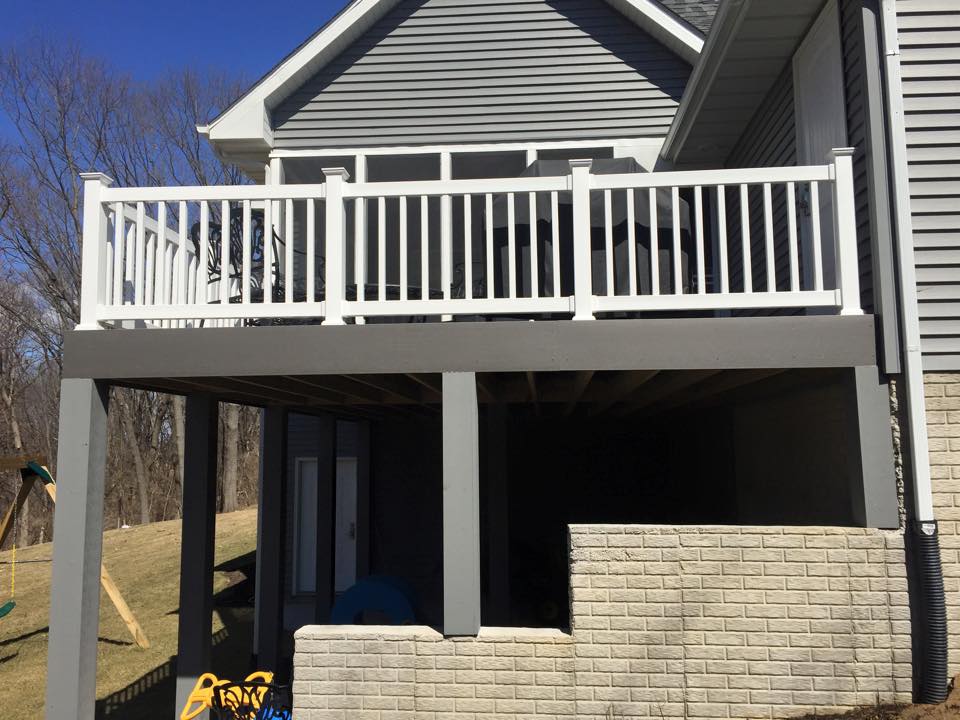 A house with a large deck and a white railing.