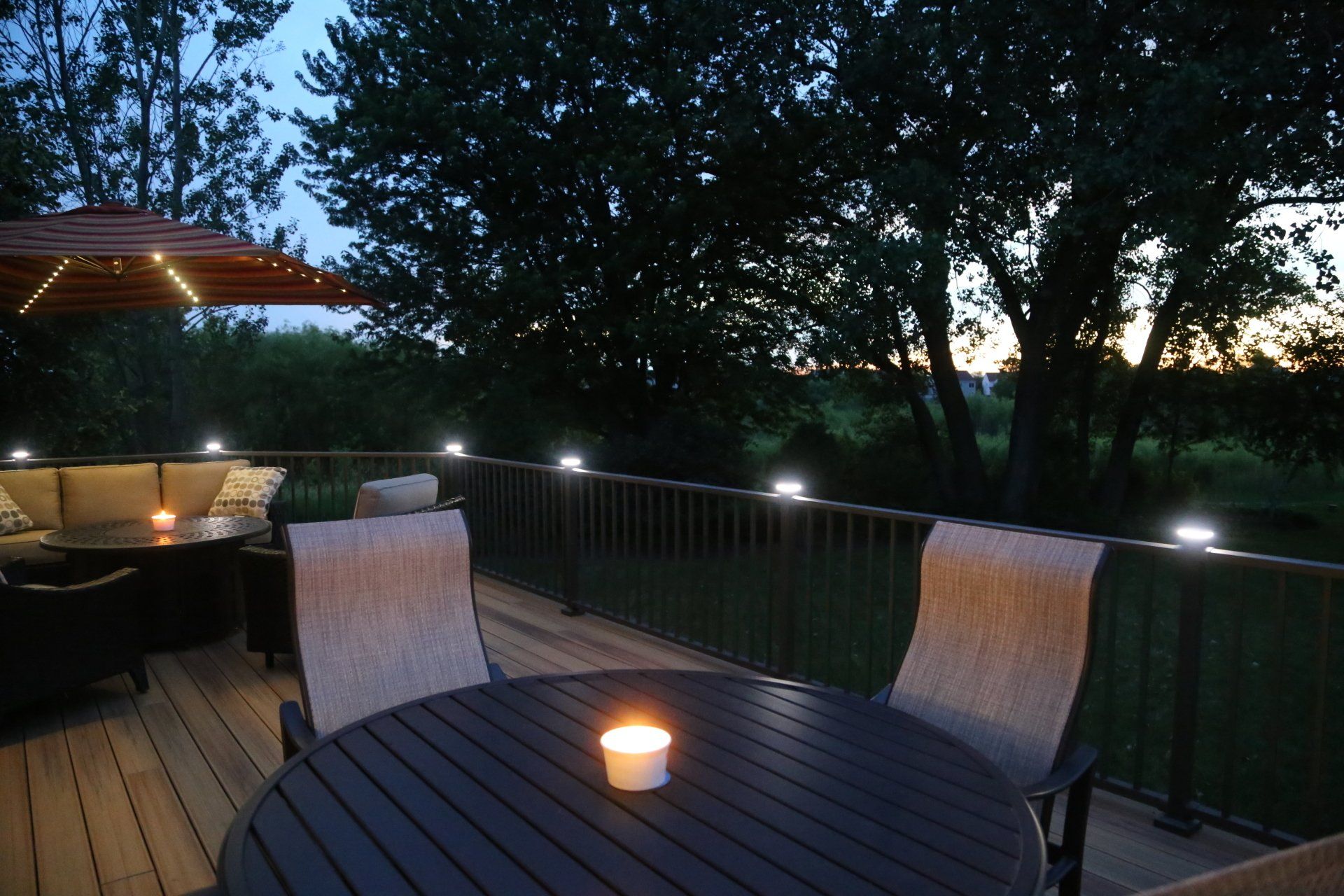 A deck with a table and chairs and a candle on it
