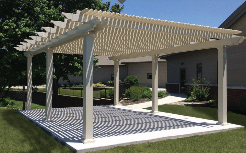 A white pergola is in the backyard of a house