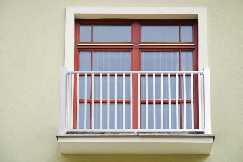 A window with a balcony on the side of a building.