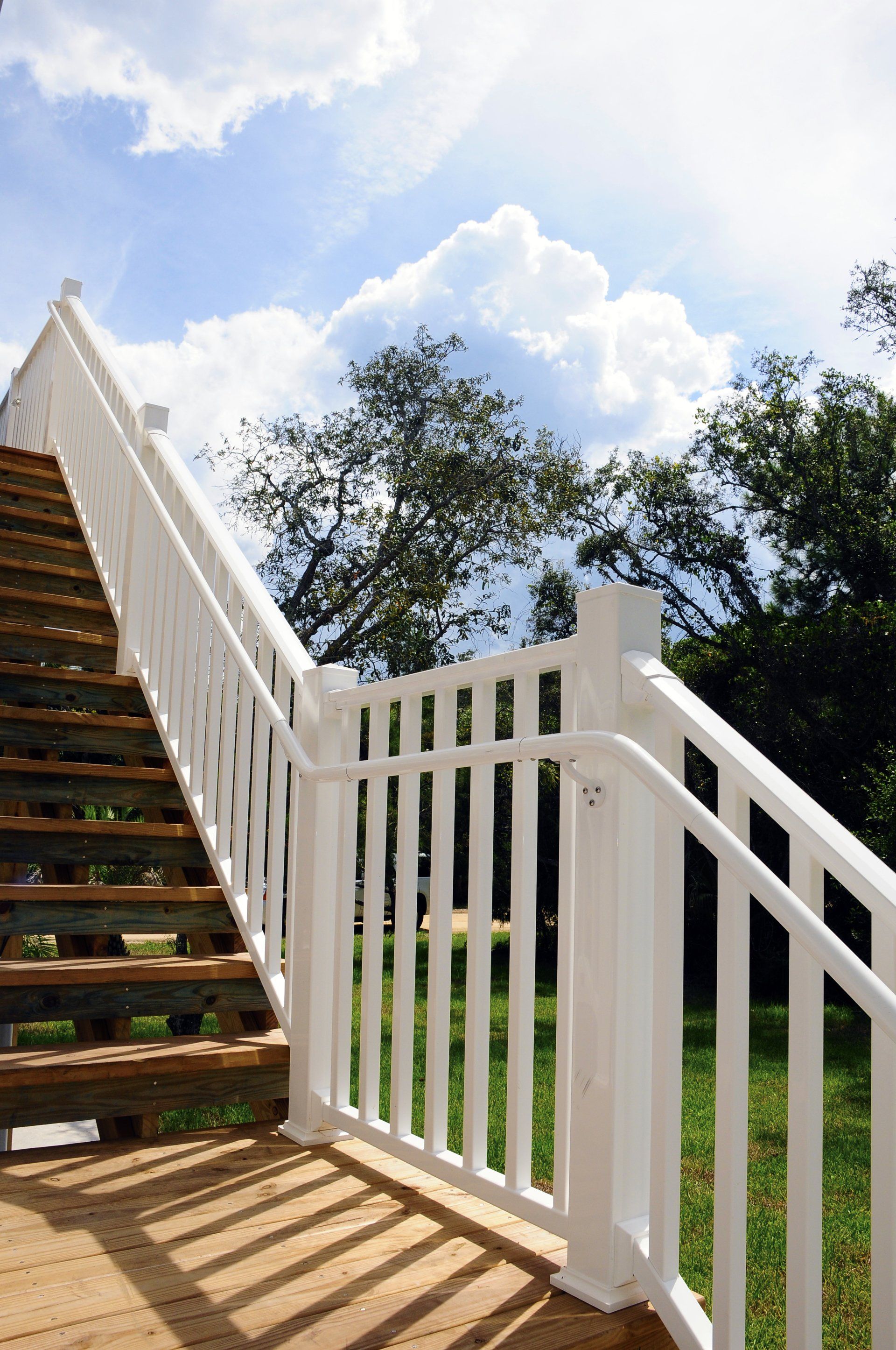 A white railing leading up to a set of stairs