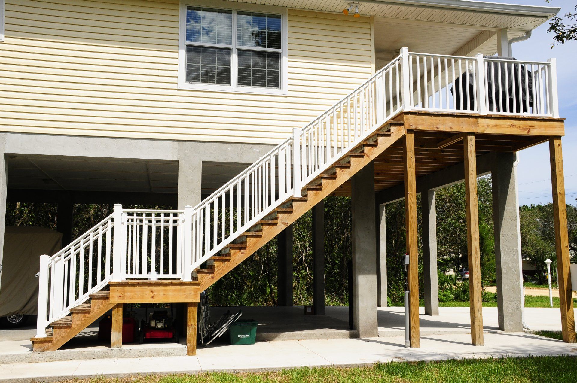 A house with a wooden deck and stairs leading up to it.